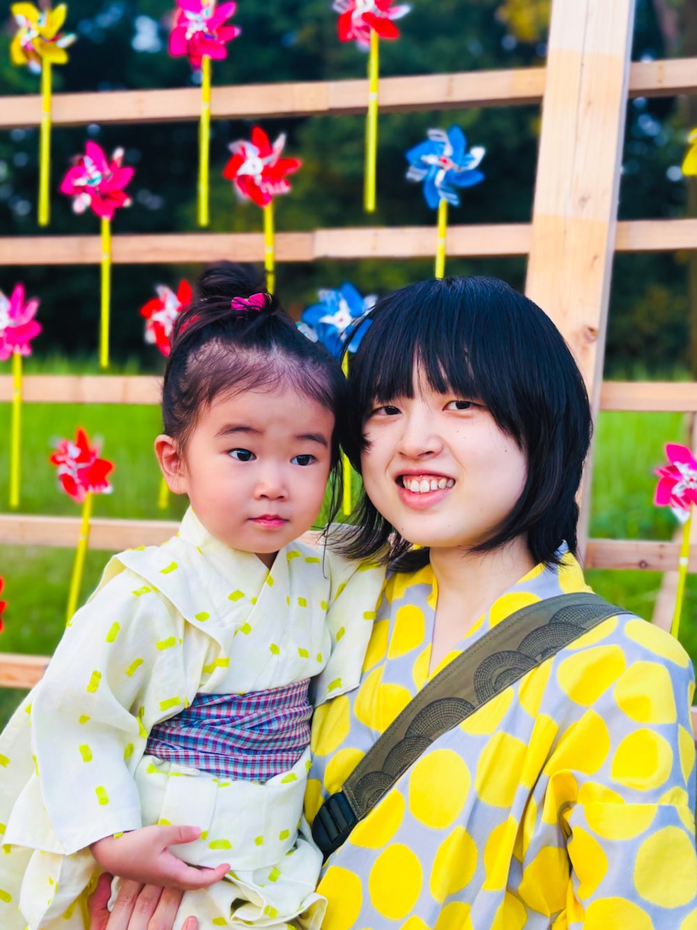 ピンク系のサンダル、レッド系のヘアゴム、ブルー系のストール/ショールを着用したキッズの夏コーディネートの3枚目の写真