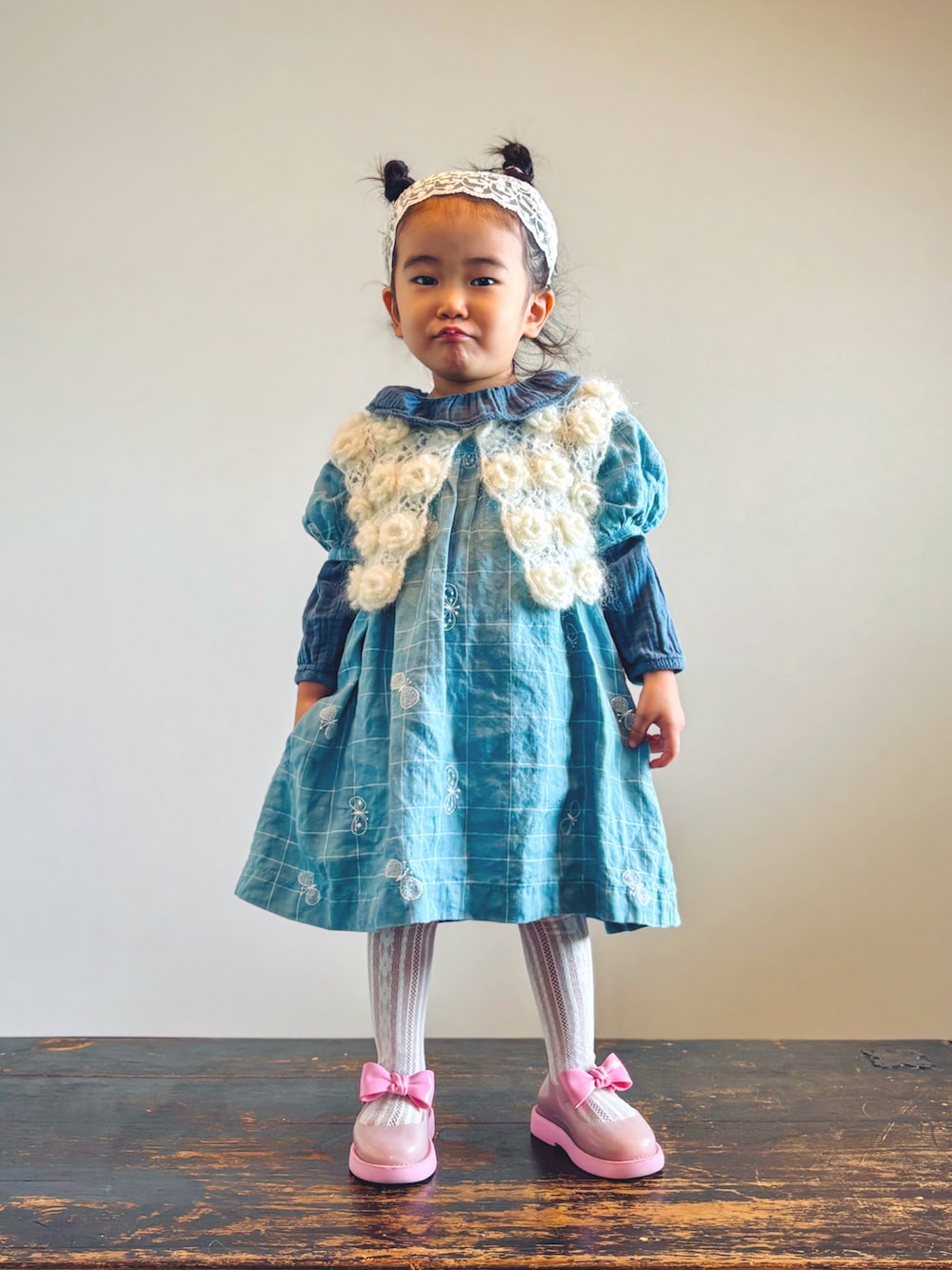 ホワイト系のカーディガン/ボレロ、グリーン系のシャツ/ブラウス、ブルー系のワンピースを着用したキッズの秋コーディネートの2枚目の写真