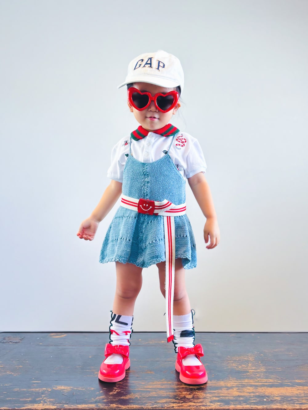 ホワイト系のポロシャツ、グリーン系のワンピース、レッド系のドレスシューズを着用したキッズの夏コーディネートの3枚目の写真