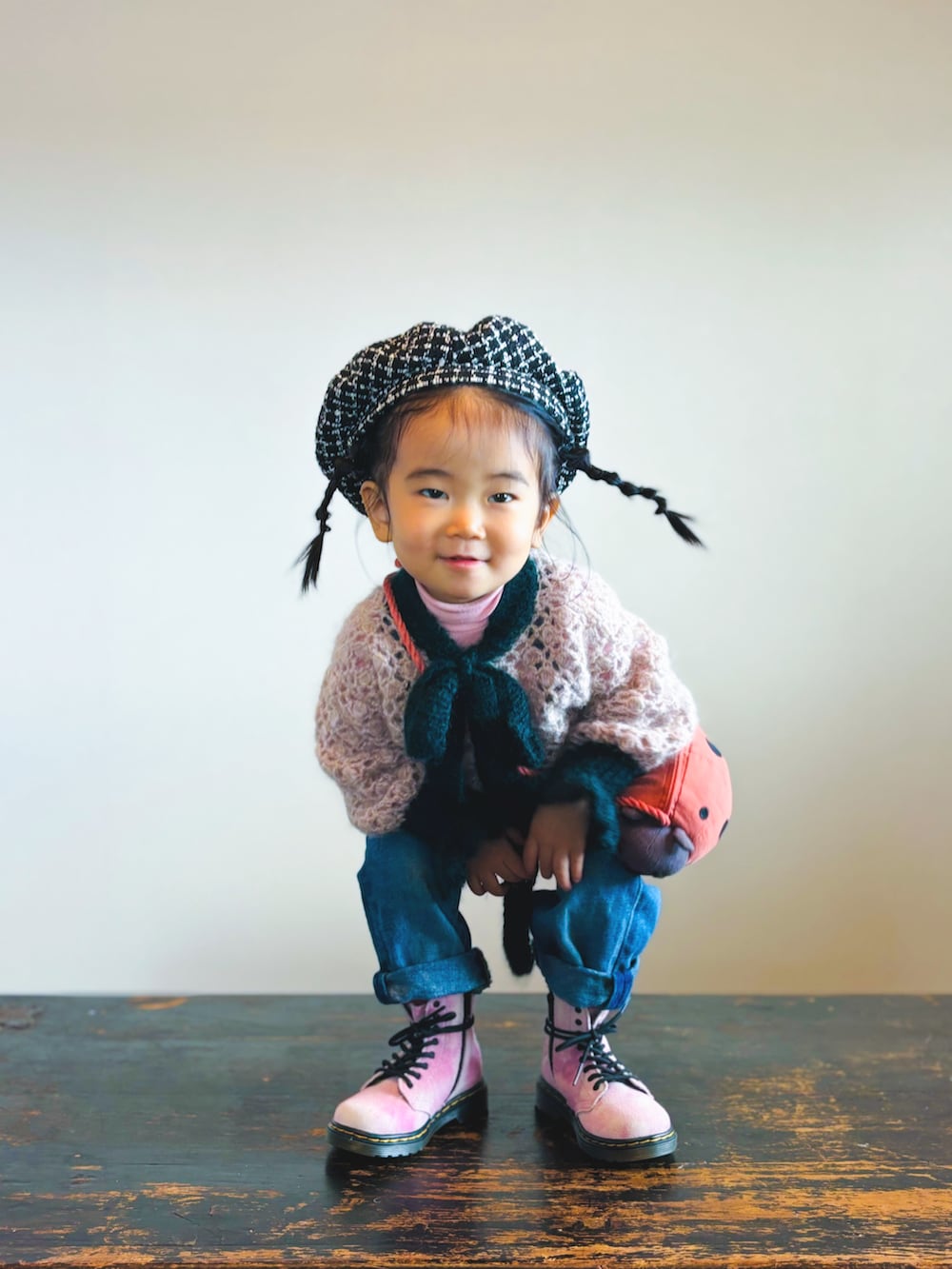 ブルー系のデニムパンツ、ピンク系のブーツ、ピンク系のニット/セーターを着用したキッズの冬コーディネートの2枚目の写真