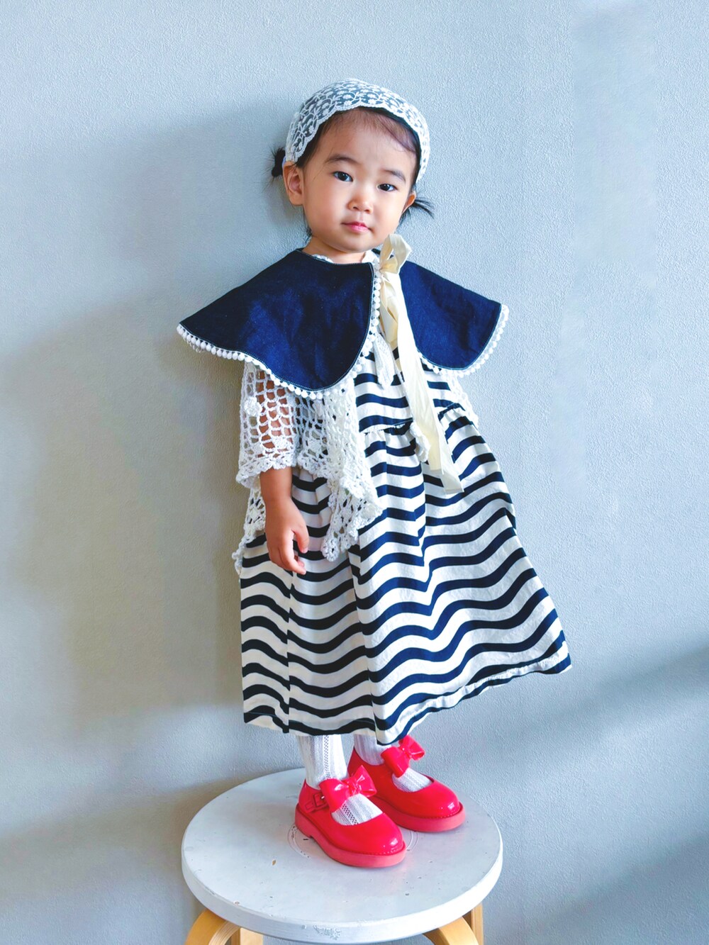 ブラック系のワンピース、レッド系のドレスシューズ、ホワイト系のソックス/靴下を着用したキッズの秋コーディネートの2枚目の写真