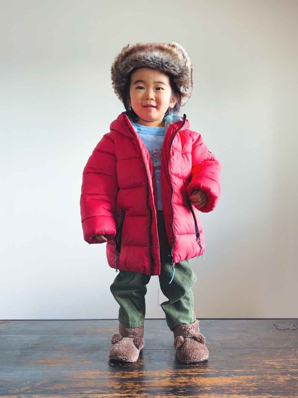 グリーン系のパンツ、ブラウン系のその他シューズ、レッド系のダウンジャケット/コートを着用したキッズの冬コーディネートの2枚目の写真