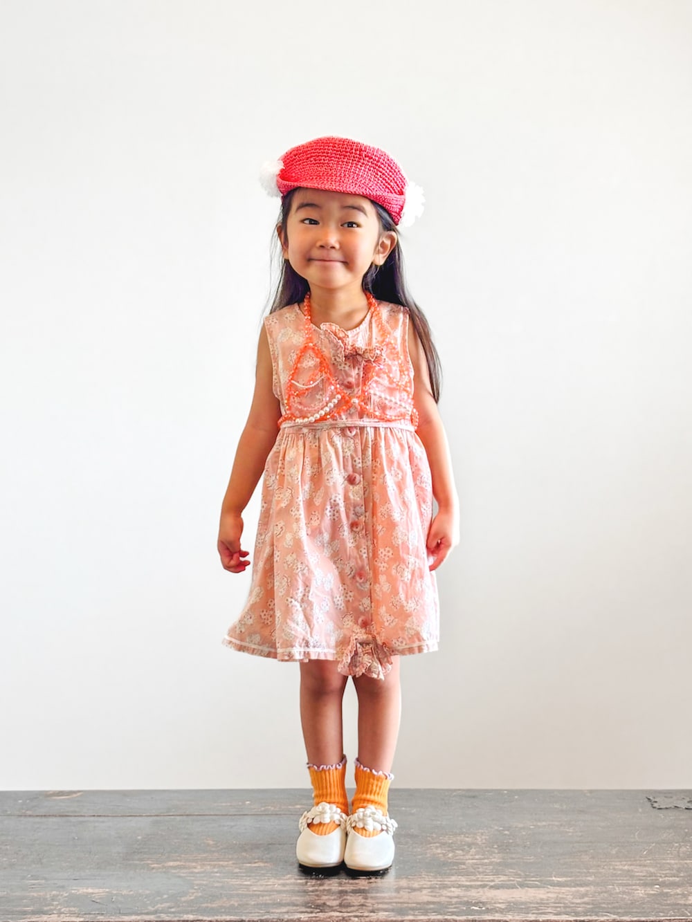 ピンク系のワンピース、ホワイト系のパンプス、その他のソックス/靴下を着用したキッズの夏コーディネートの2枚目の写真