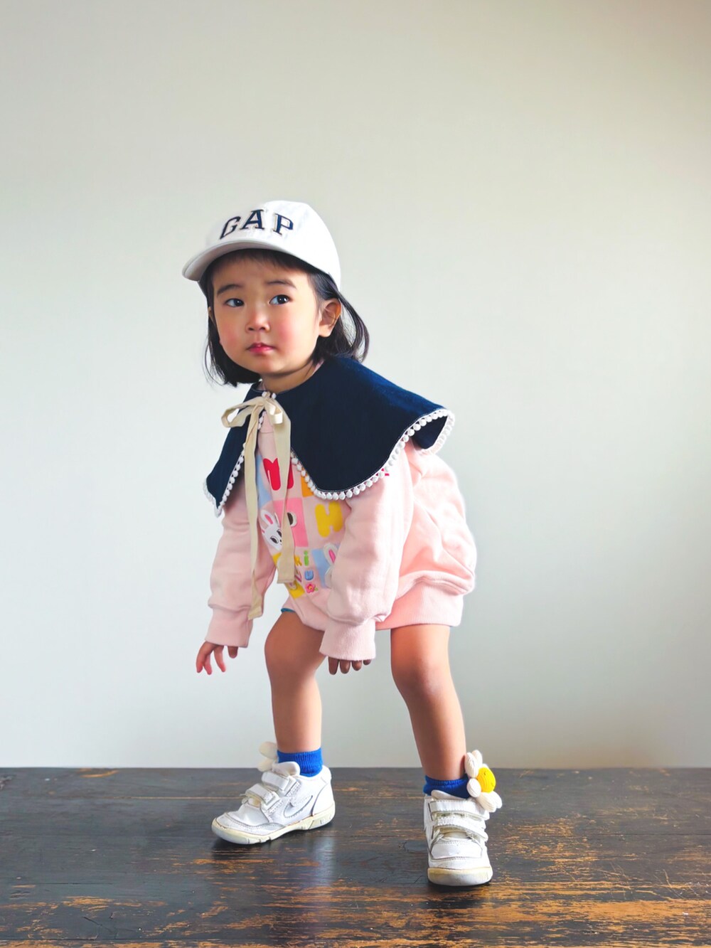 ホワイト系のスニーカー、オレンジ系のその他パンツ、ピンク系のスウェットを着用したキッズの春コーディネートの2枚目の写真