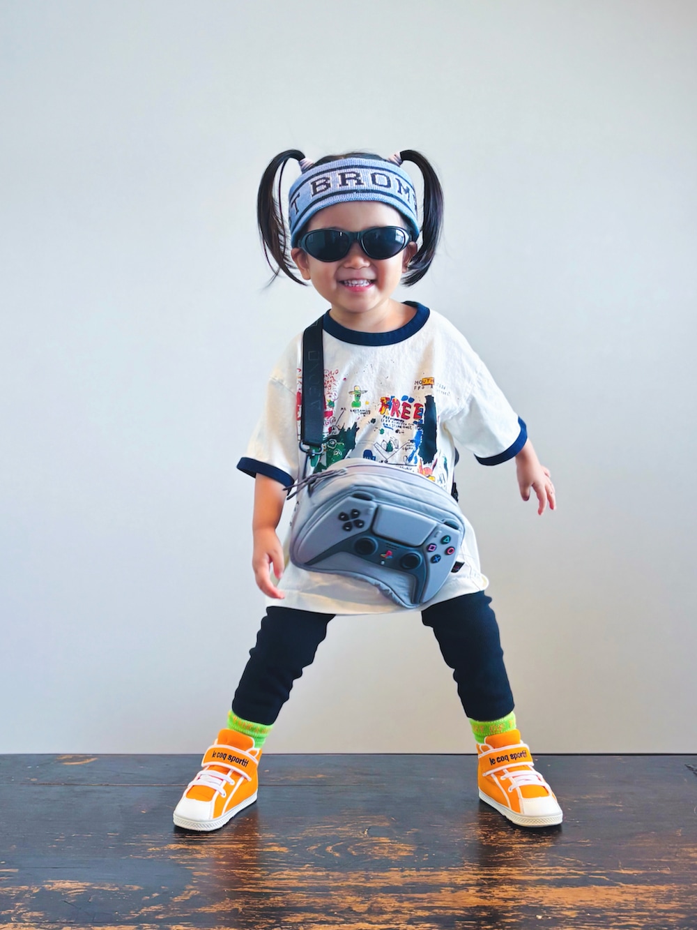 オレンジ系のスニーカー、ホワイト系のTシャツ/カットソー、ブラック系のパンツを着用したキッズの夏コーディネートの3枚目の写真