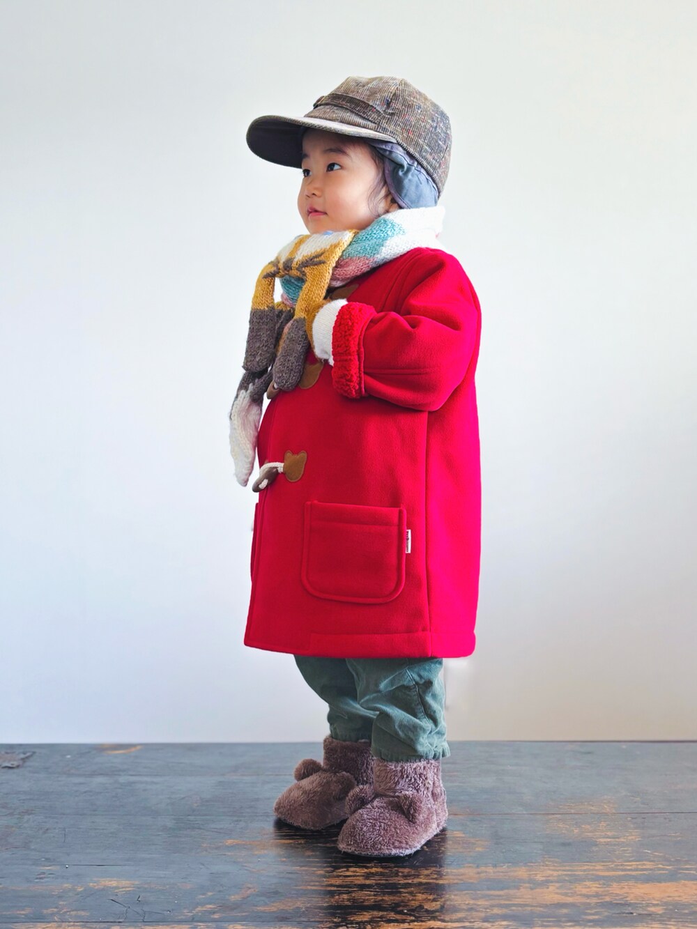 レッド系のダッフルコート、グリーン系のパンツ、ブラウン系のその他シューズを着用したキッズの冬コーディネートの3枚目の写真