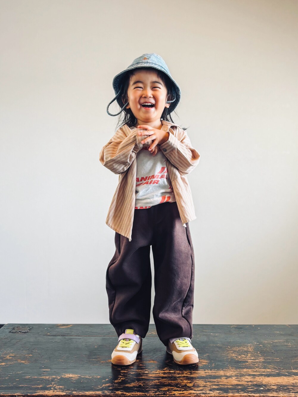 イエロー系のスニーカー、ホワイト系のタンクトップ、ベージュ系のシャツ/ブラウスを着用したキッズの秋コーディネートの4枚目の写真