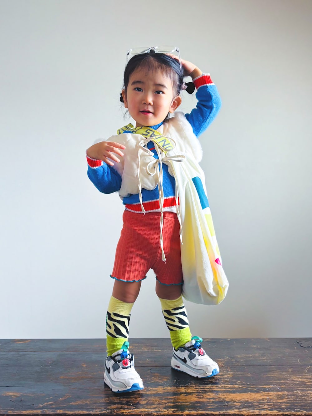 ホワイト系のスニーカー、オレンジ系のその他パンツ、ホワイト系のベストを着用したキッズの春コーディネートの2枚目の写真