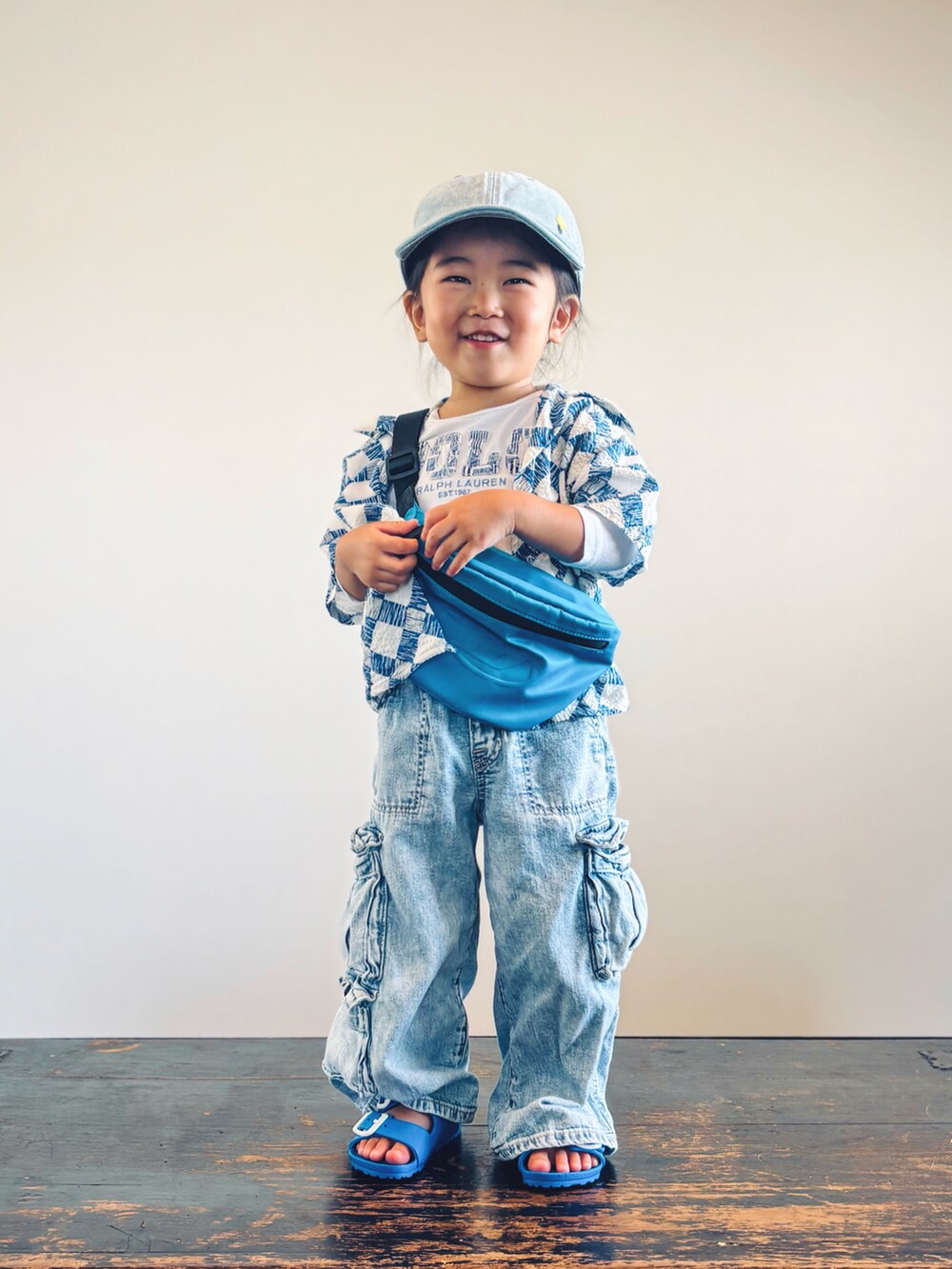 ブルー系のデニムパンツ、ブルー系のサンダル、ブルー系のボディバッグ/ウエストポーチを着用したキッズの秋コーディネートの2枚目の写真