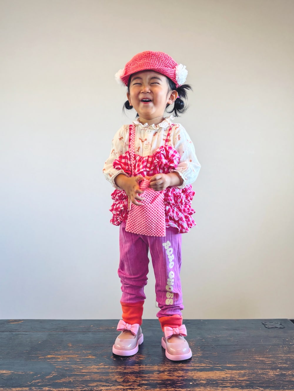 ピンク系のキャミソール、ベージュ系のシャツ/ブラウス、ピンク系のショルダーバッグを着用したキッズの秋コーディネートの2枚目の写真