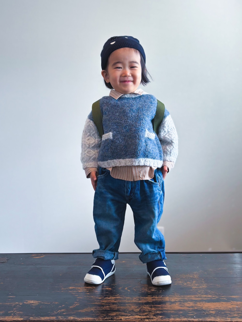 グリーン系のバックパック/リュック、ブルー系のニット/セーター、ベージュ系のシャツ/ブラウスを着用したキッズの冬コーディネートの2枚目の写真