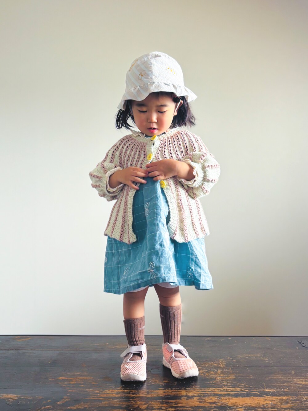 ピンク系のスニーカー、ブルー系のワンピース、ピンク系のカーディガン/ボレロを着用したキッズの春コーディネートの2枚目の写真