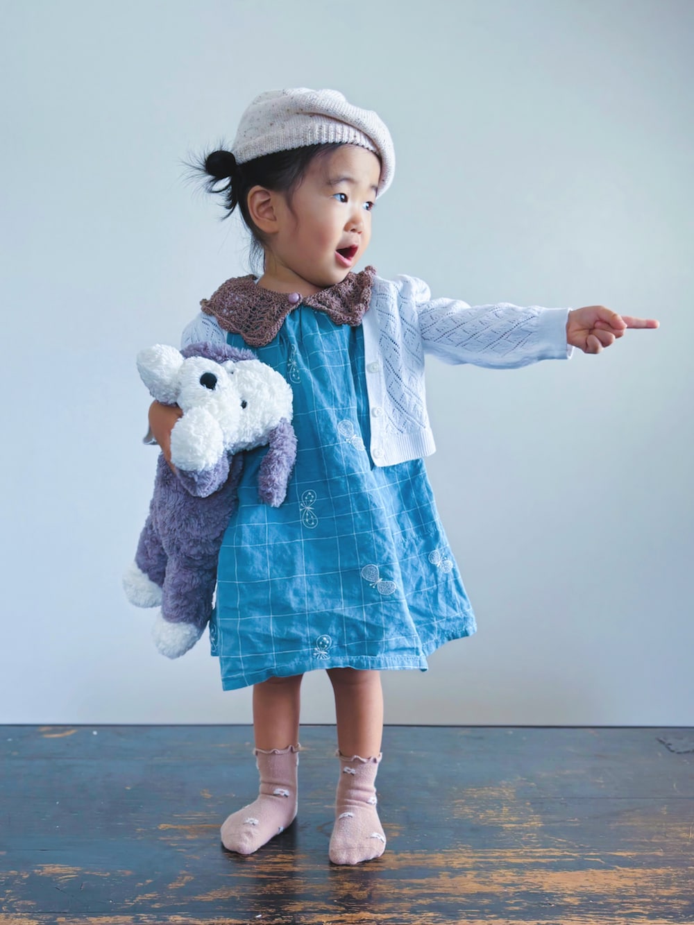 ホワイト系のカーディガン/ボレロ、ブルー系のワンピース、ホワイト系のハンチング/ベレー帽を着用したキッズの秋コーディネートの2枚目の写真