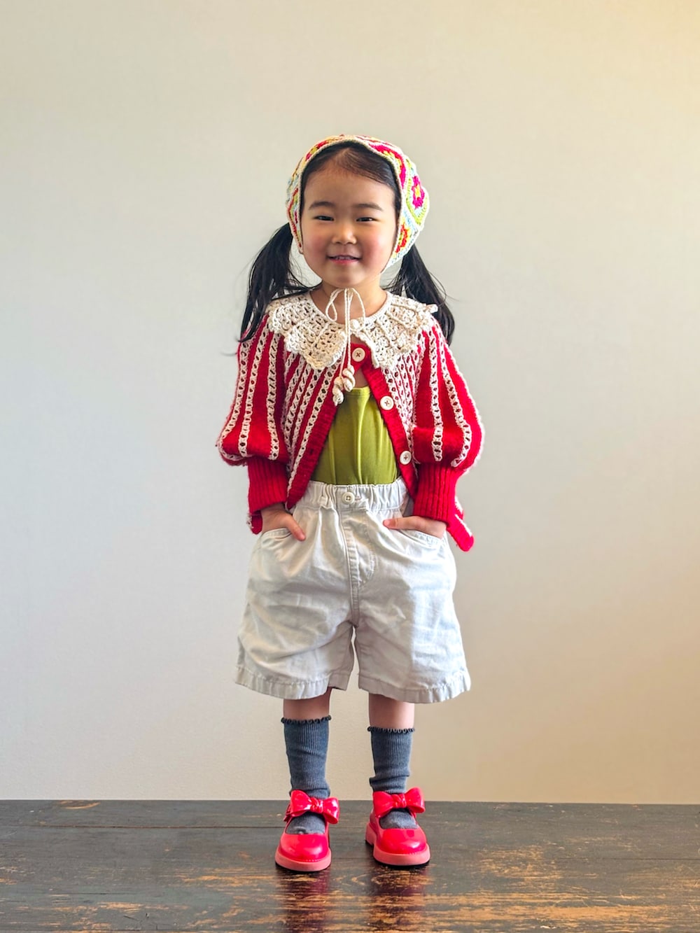 グリーン系のキャミソール、レッド系のニット/セーター、ホワイト系のその他パンツを着用したキッズの春コーディネートの2枚目の写真