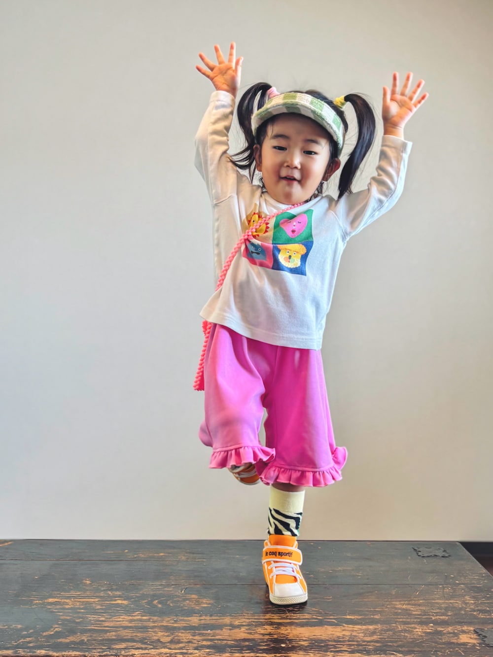 ピンク系のその他パンツ、オレンジ系のスニーカー、ホワイト系のTシャツ/カットソーを着用したキッズの秋コーディネートの4枚目の写真