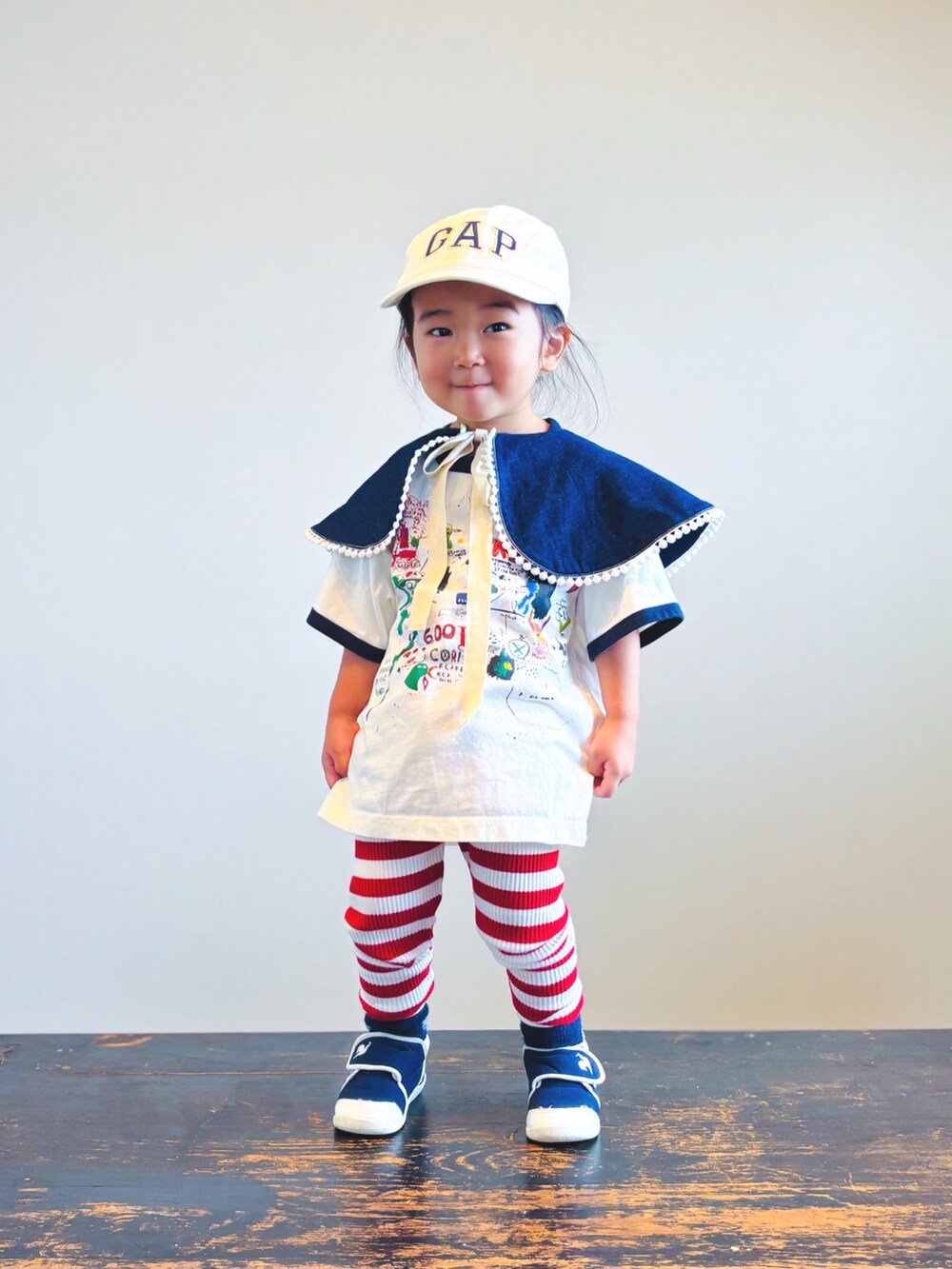 ブルー系のスニーカー、ホワイト系のTシャツ/カットソー、ホワイト系のキャップを着用したキッズの秋コーディネートの3枚目の写真