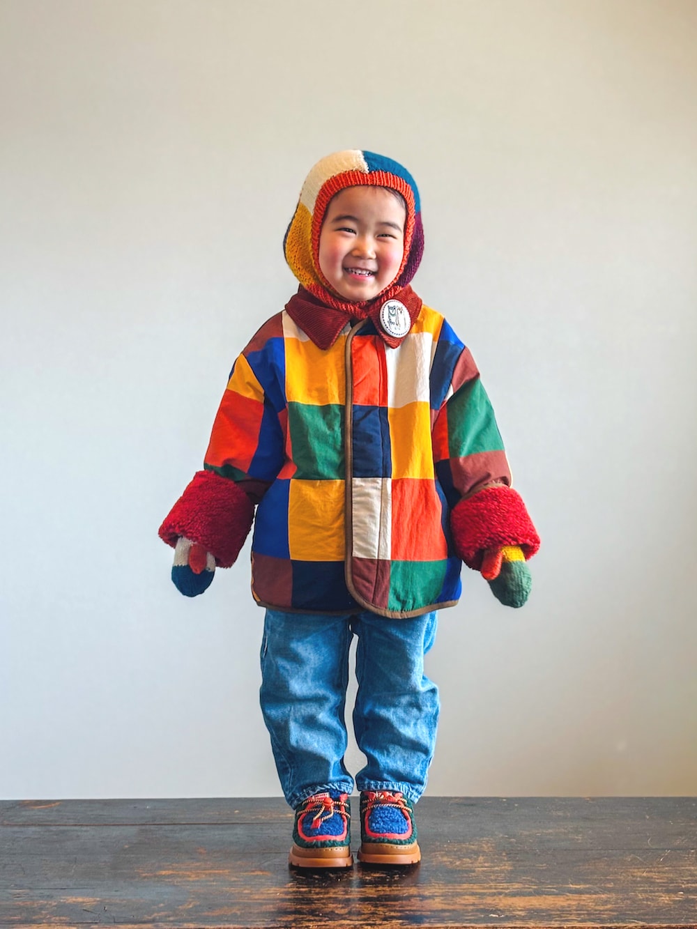 グリーン系のブーツ、ブルー系のデニムパンツ、その他のブルゾンを着用したキッズの冬コーディネートの2枚目の写真