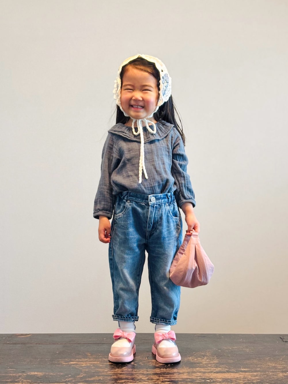 グリーン系のシャツ/ブラウス、ブルー系のデニムパンツ、ピンク系のショルダーバッグを着用したキッズの春コーディネートの3枚目の写真