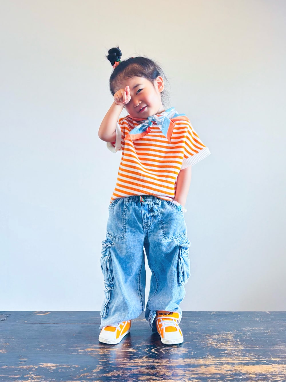 ブルー系のデニムパンツ、オレンジ系のスニーカー、オレンジ系のTシャツ/カットソーを着用したキッズの秋コーディネートの3枚目の写真