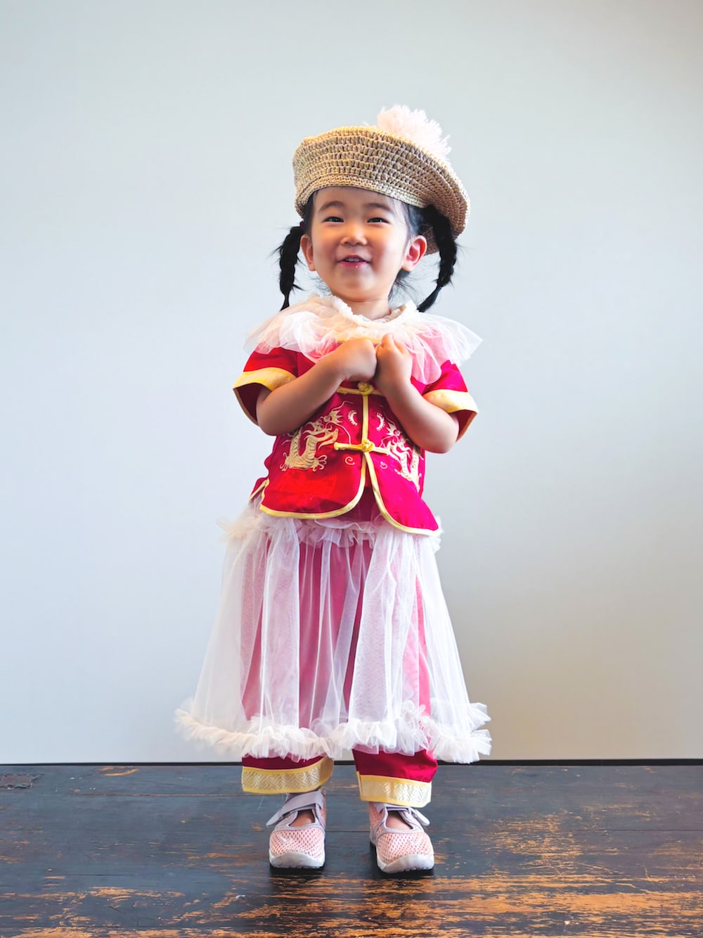 ホワイト系のワンピース、ピンク系のスニーカー、レッド系のセットアップを着用したキッズの夏コーディネートの2枚目の写真