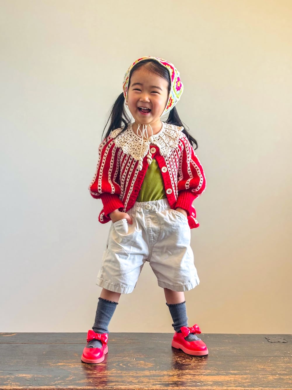 グリーン系のキャミソール、レッド系のニット/セーター、ホワイト系のその他パンツを着用したキッズの春コーディネートの3枚目の写真