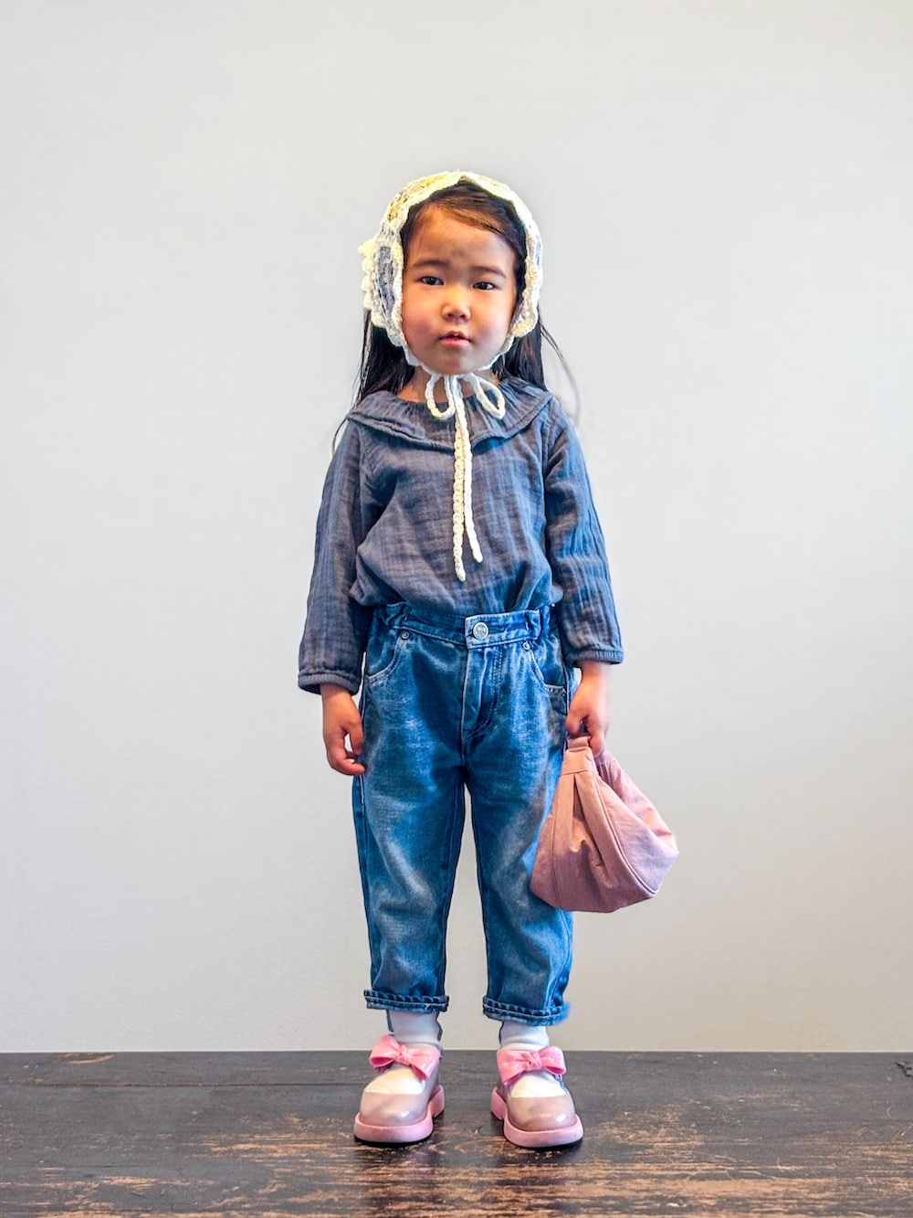 グリーン系のシャツ/ブラウス、ブルー系のデニムパンツ、ピンク系のショルダーバッグを着用したキッズの春コーディネートの2枚目の写真