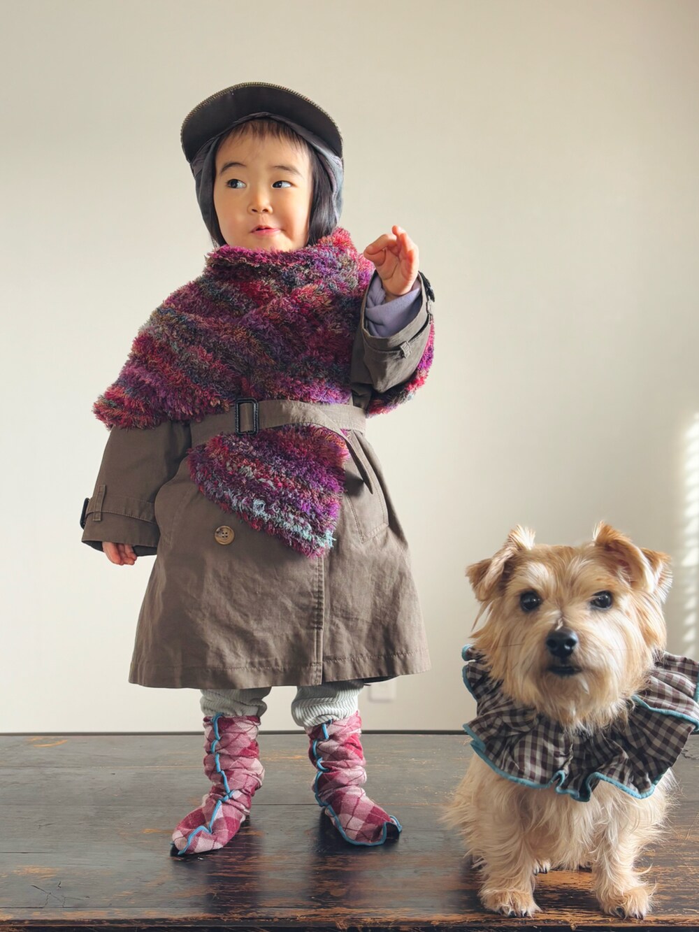 グリーン系のその他パンツ、パープル系のポンチョ、グリーン系のトレンチコートを着用したキッズの冬コーディネートの4枚目の写真