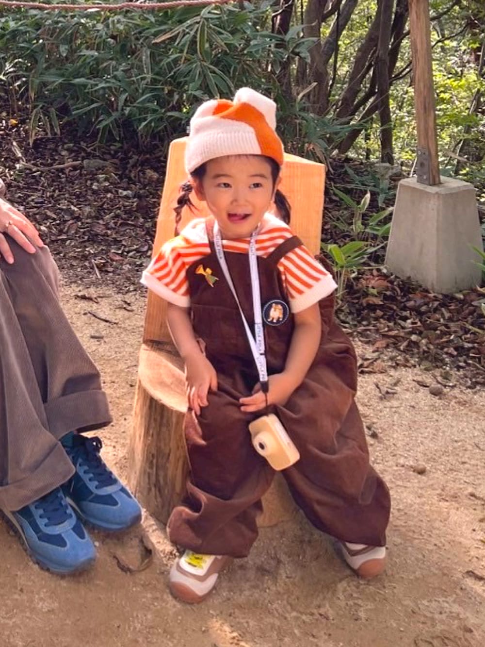 イエロー系のスニーカー、オレンジ系のTシャツ/カットソー、ブラウン系のサロペット/オーバーオールを着用したキッズの秋コーディネートの4枚目の写真