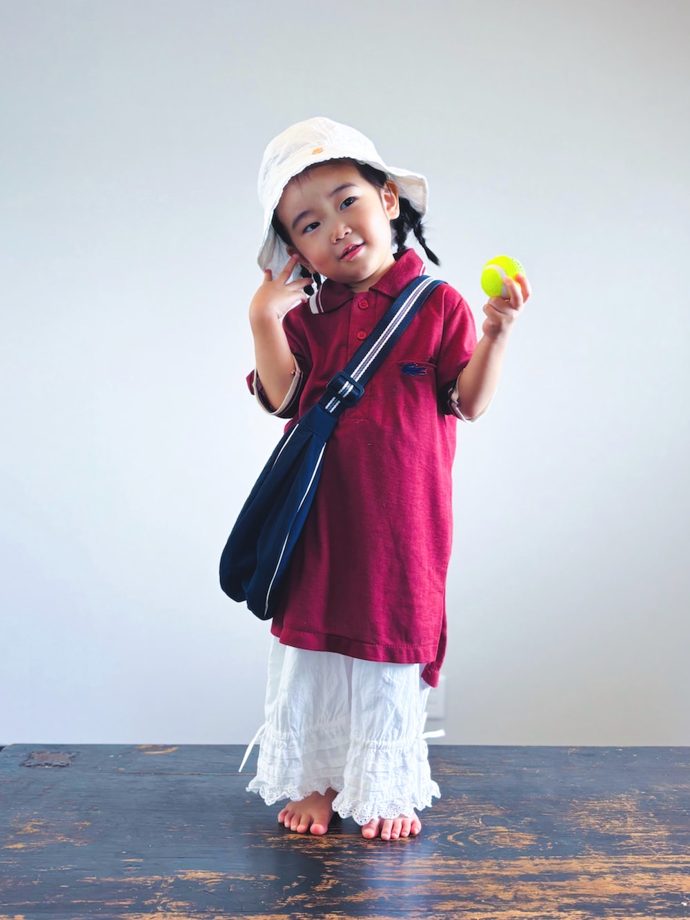 ホワイト系のその他パンツ、レッド系のシャツ/ブラウス、ブルー系のショルダーバッグを着用したキッズの夏コーディネートの2枚目の写真