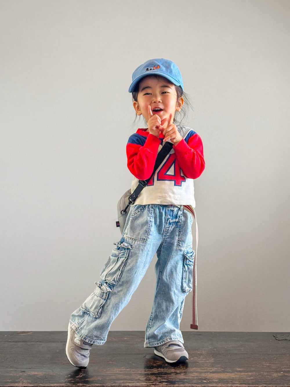 グレー系のスニーカー、ブルー系のデニムパンツ、レッド系のTシャツ/カットソーを着用したキッズの春コーディネートの2枚目の写真
