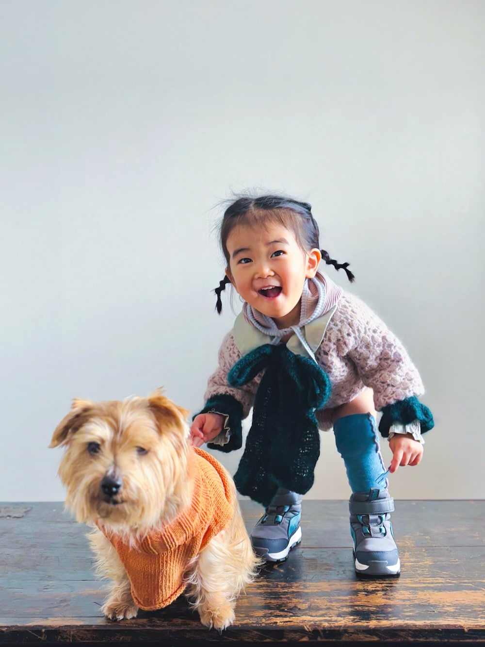 ピンク系のニット/セーター、グリーン系のシャツ/ブラウス、ブラウン系のセットアップを着用したキッズの冬コーディネートの2枚目の写真