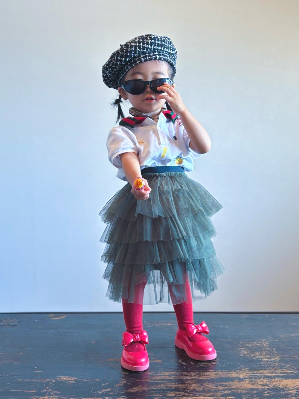 グリーン系のスカート、レッド系のドレスシューズ、ホワイト系のポロシャツを着用したキッズの秋コーディネートの2枚目の写真