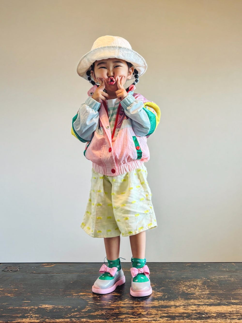 グリーン系のTシャツ/カットソー、ピンク系のセットアップ、イエロー系のパンツを着用したキッズの秋コーディネートの3枚目の写真