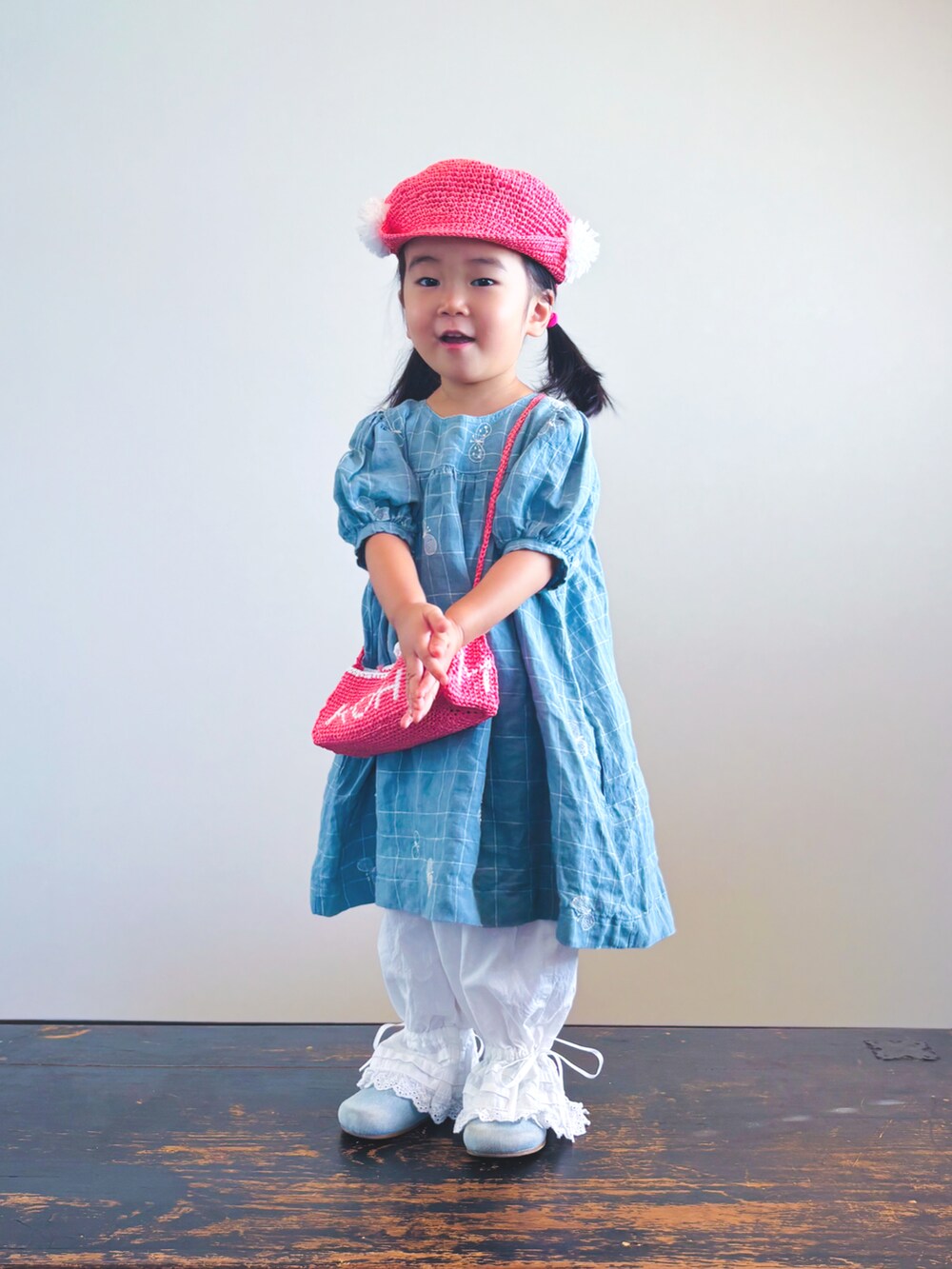 ホワイト系のその他パンツ、ブルー系のワンピース、ピンク系のショルダーバッグを着用したキッズの夏コーディネートの3枚目の写真