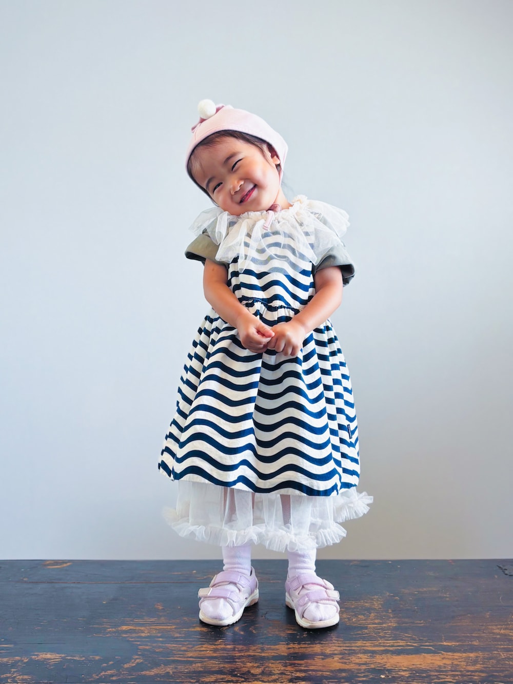 ホワイト系のワンピース、グリーン系のTシャツ/カットソー、ブラック系のワンピースを着用したキッズの秋コーディネートの2枚目の写真