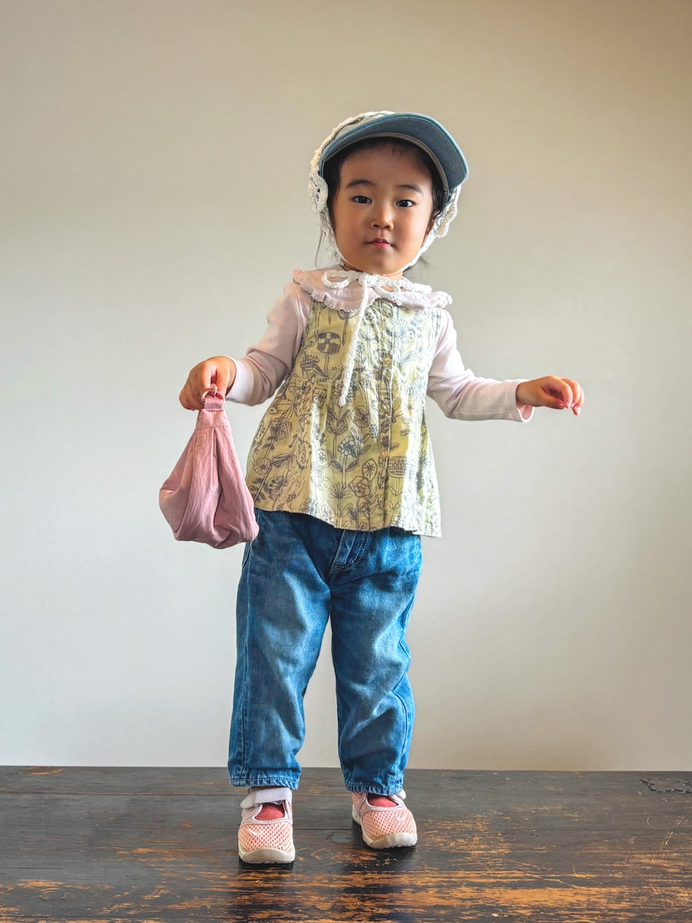 ピンク系のスニーカー、ピンク系のTシャツ/カットソー、ブルー系のデニムパンツを着用したキッズの秋コーディネートの2枚目の写真