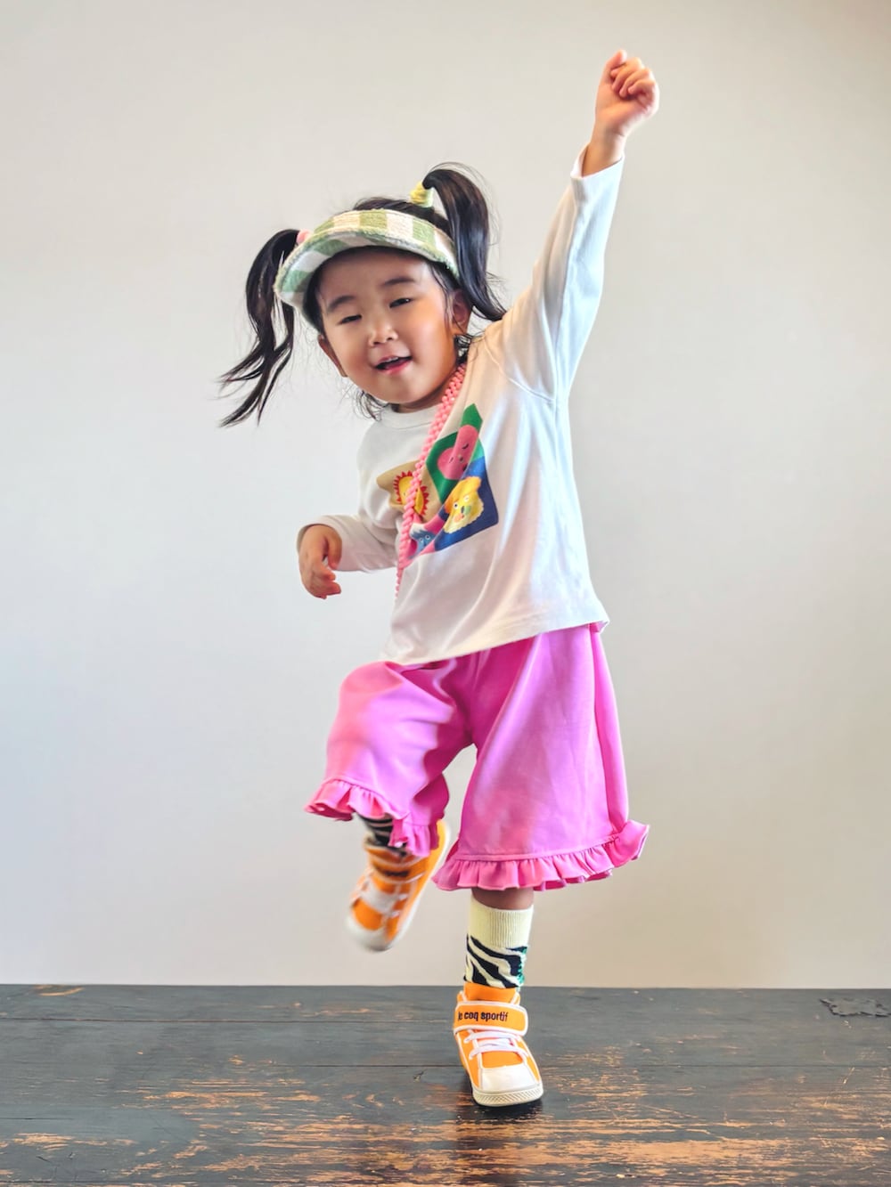 ピンク系のその他パンツ、オレンジ系のスニーカー、ホワイト系のTシャツ/カットソーを着用したキッズの秋コーディネートの2枚目の写真