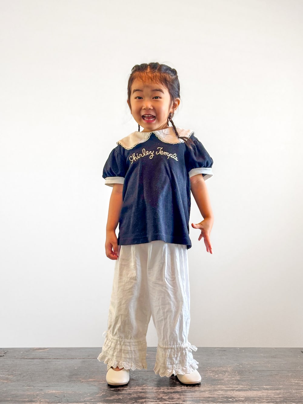 ホワイト系のその他パンツ、ブラック系のTシャツ/カットソー、ホワイト系のパンプスを着用したキッズの夏コーディネートの3枚目の写真