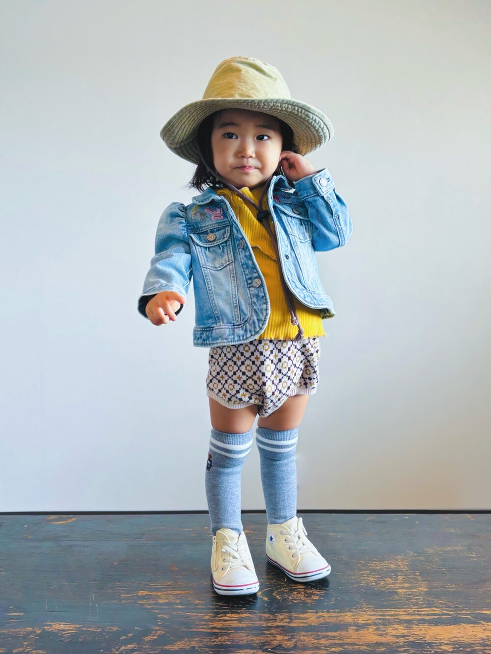 ホワイト系のスニーカー、ベージュ系のセットアップ、イエロー系のTシャツ/カットソーを着用したキッズの秋コーディネートの2枚目の写真