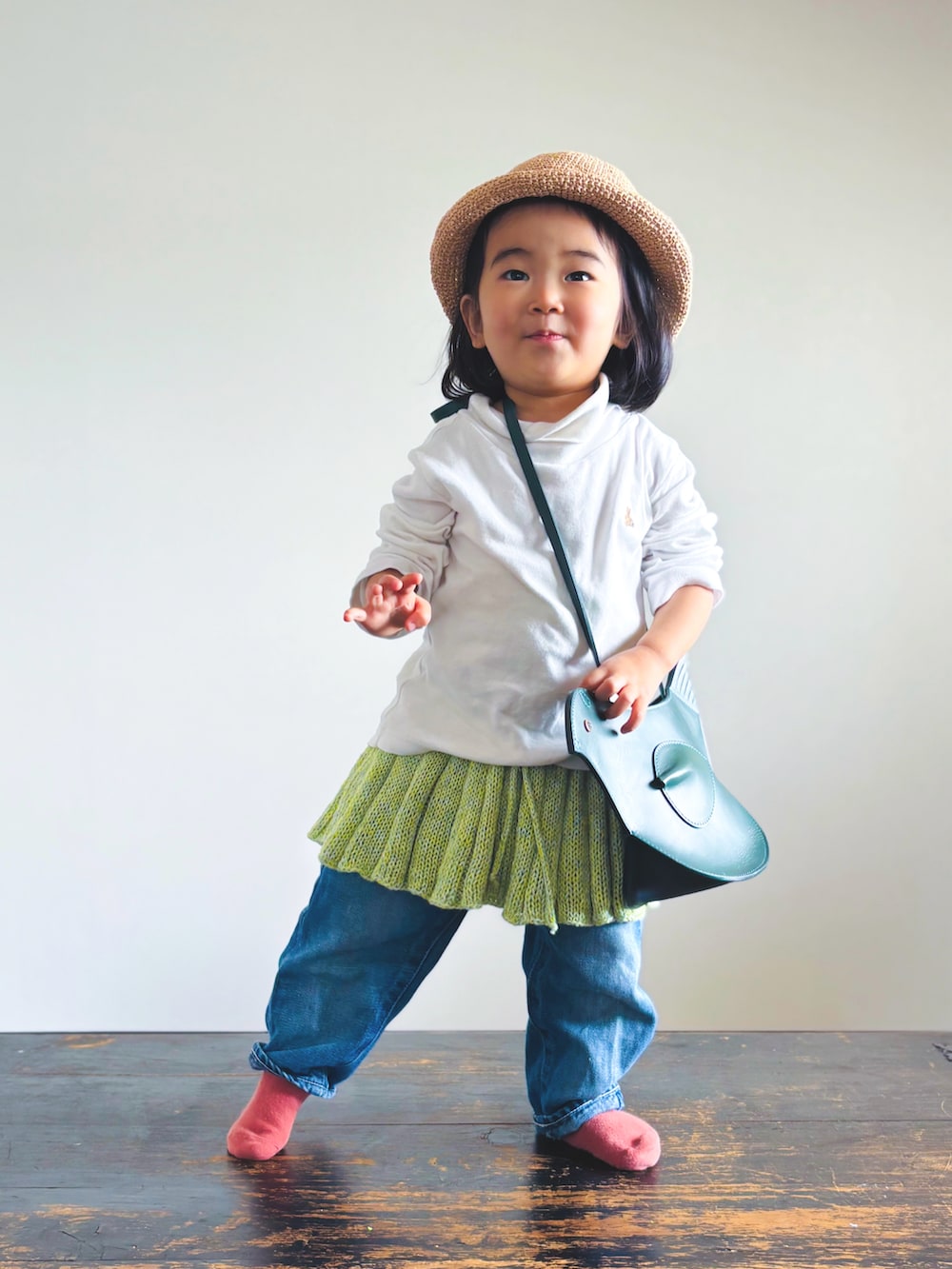 ホワイト系のTシャツ/カットソー、グリーン系のショルダーバッグ、グリーン系のスカートを着用したキッズの春コーディネートの2枚目の写真