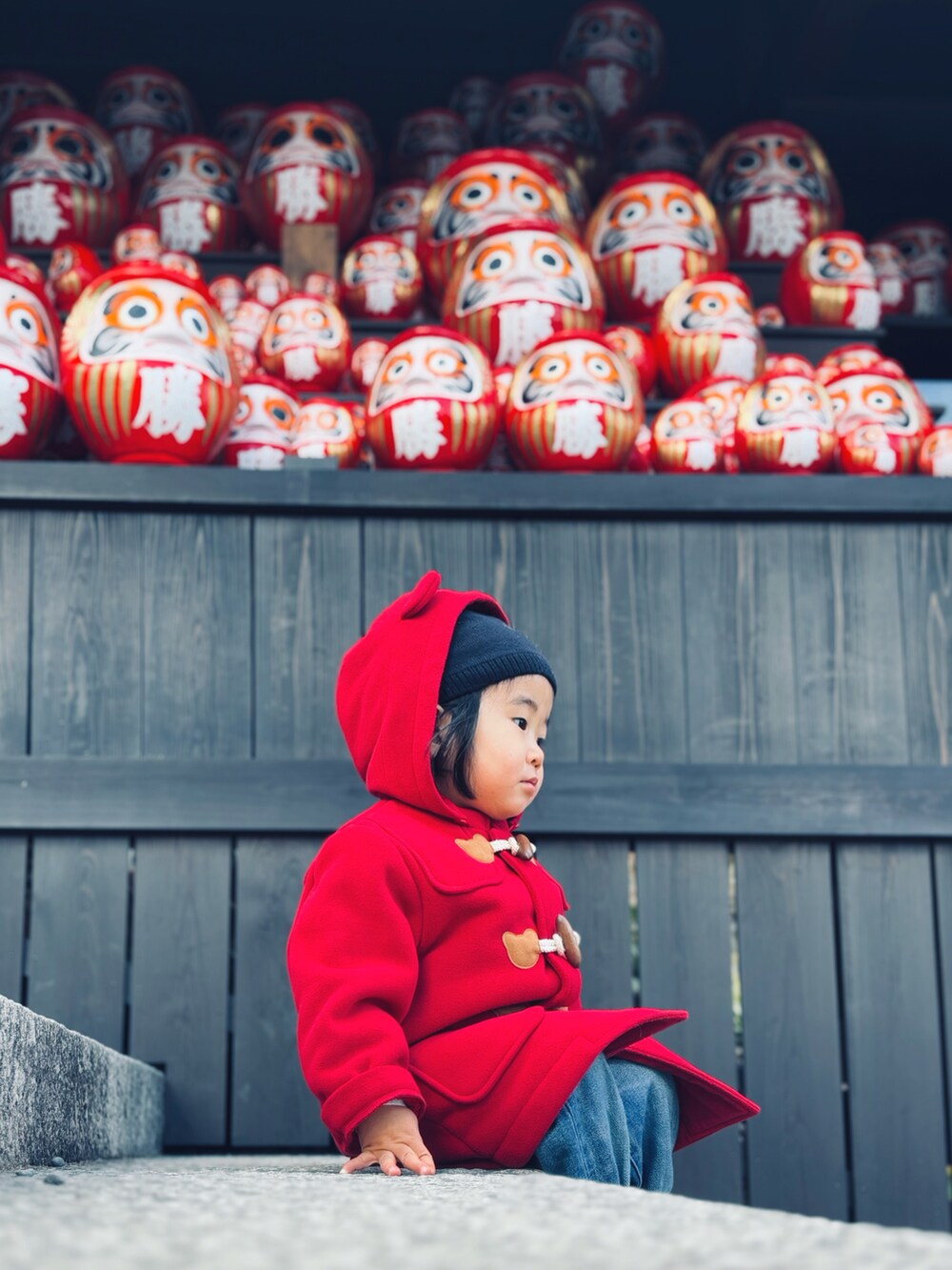 ブルー系のデニムパンツ、ブルー系のスニーカー、レッド系のダッフルコートを着用したキッズの冬コーディネートの2枚目の写真