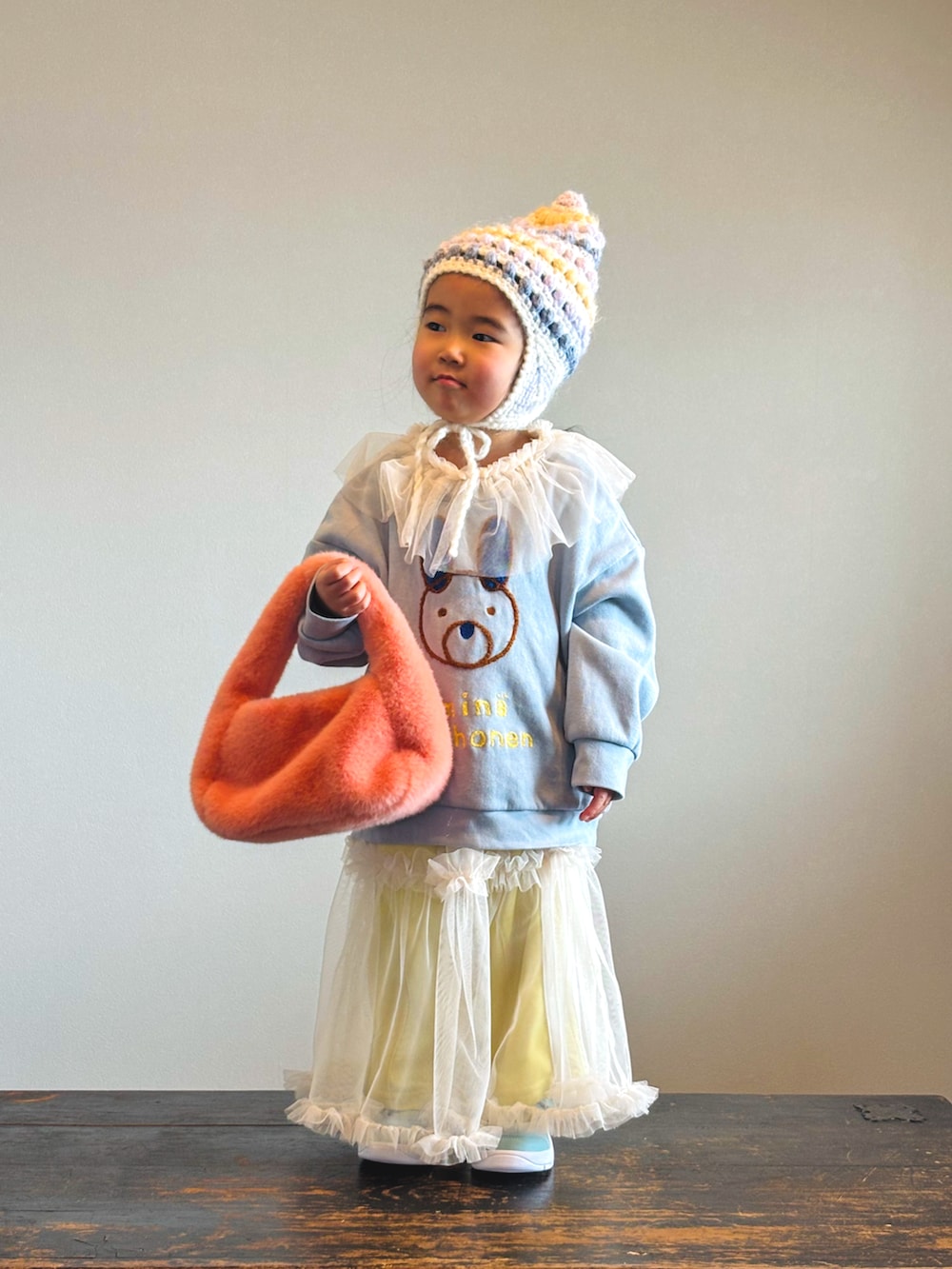 イエロー系のその他パンツ、グリーン系のスニーカー、ホワイト系のワンピースを着用したキッズの冬コーディネートの3枚目の写真