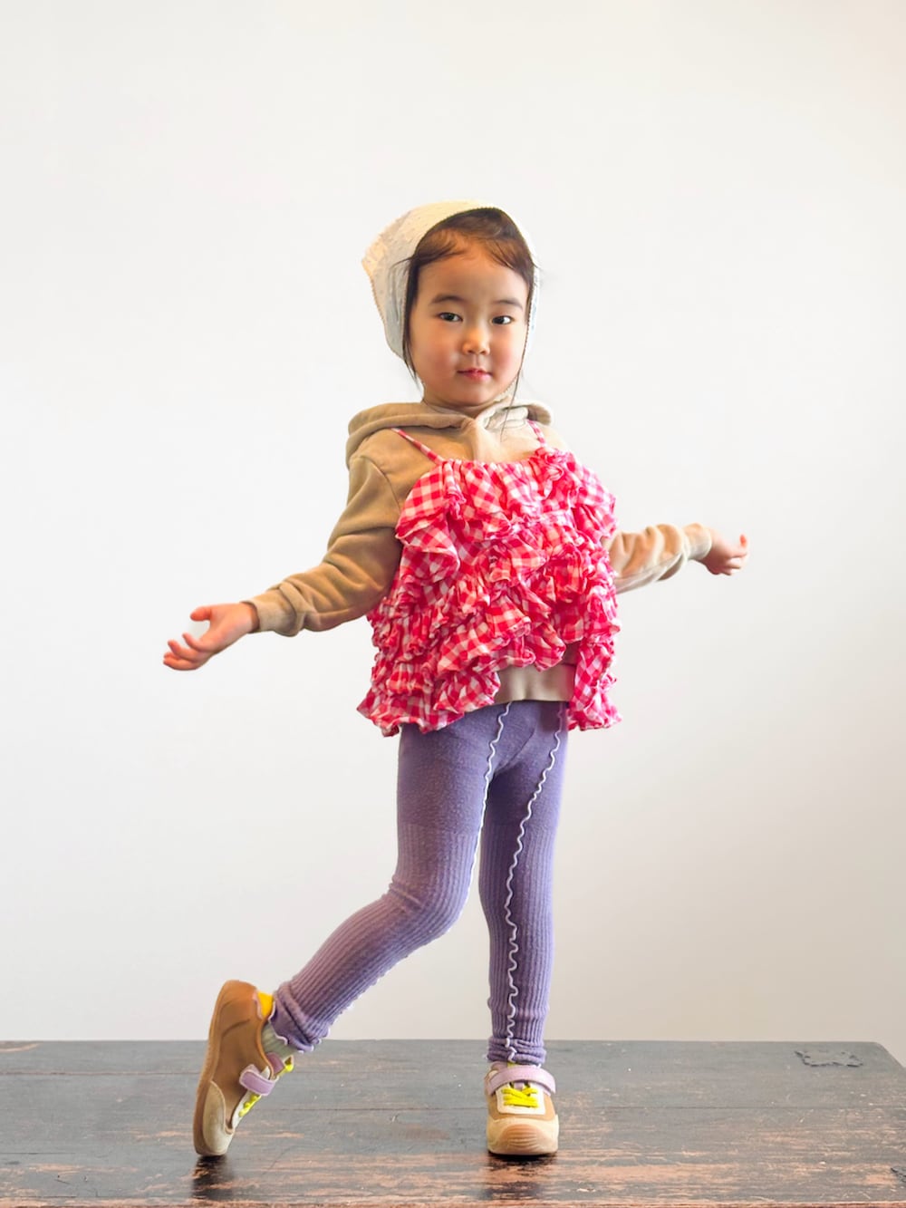 ピンク系のキャミソール、イエロー系のスニーカー、ベージュ系のパーカーを着用したキッズの春コーディネートの2枚目の写真