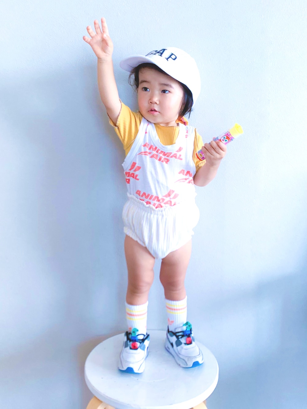 ホワイト系のタンクトップ、イエロー系のTシャツ/カットソー、ホワイト系のスニーカーを着用したキッズの夏コーディネートの2枚目の写真