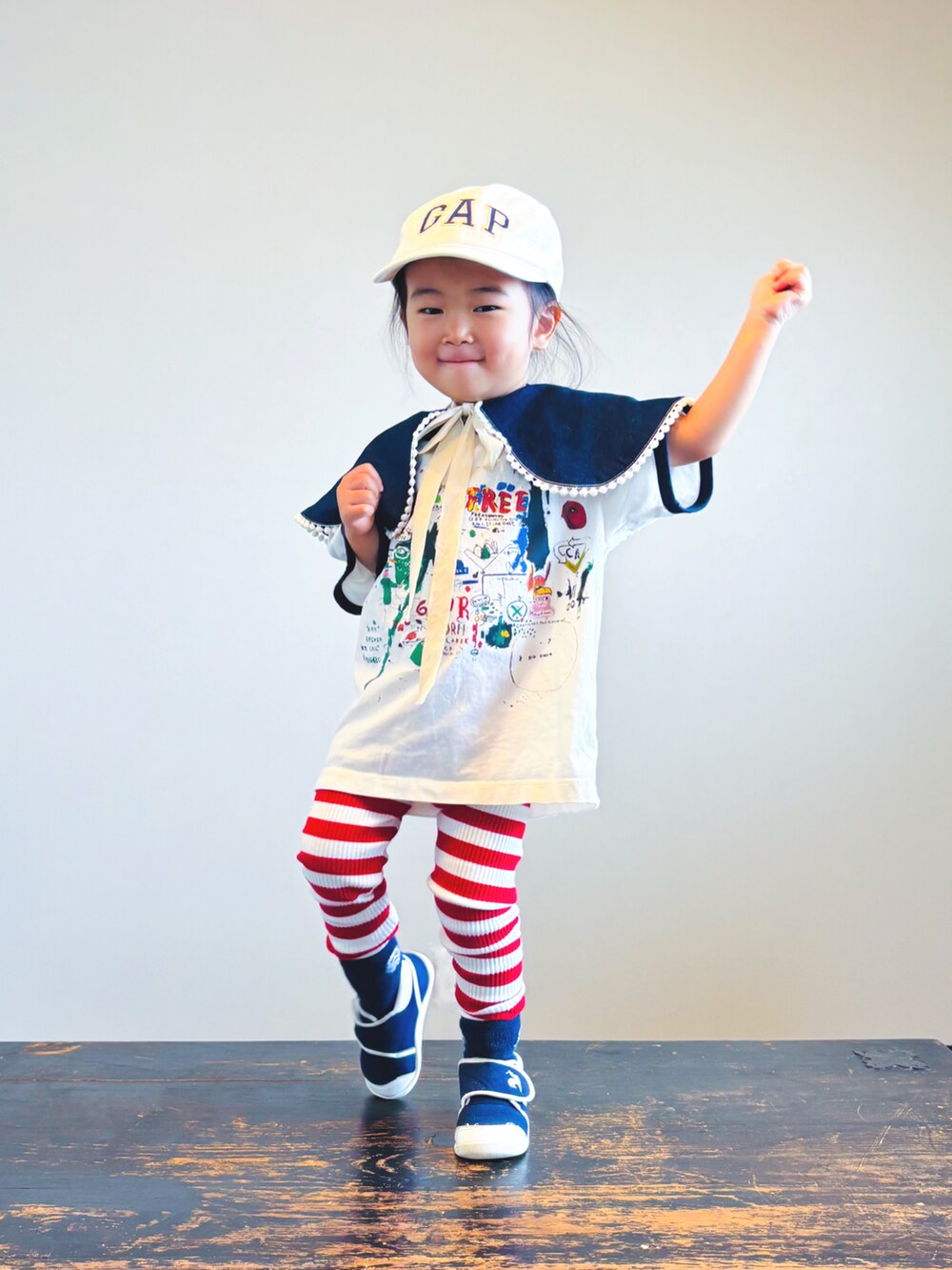 ブルー系のスニーカー、ホワイト系のTシャツ/カットソー、ホワイト系のキャップを着用したキッズの秋コーディネートの2枚目の写真