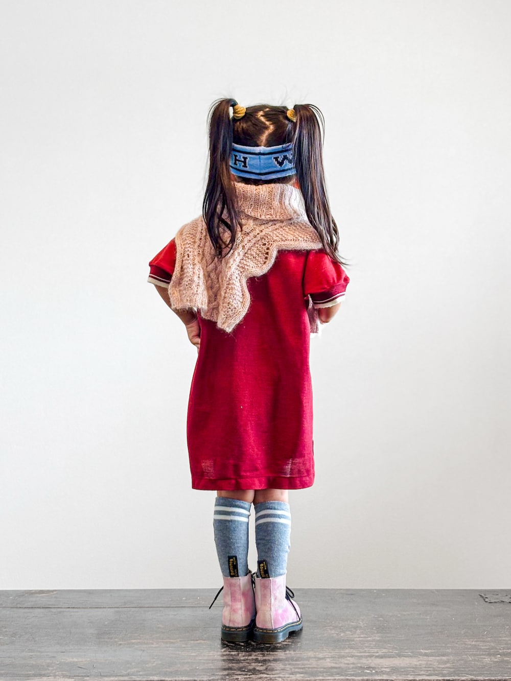 レッド系のシャツ/ブラウス、ピンク系のブーツ、ブルー系のヘアバンドを着用したキッズの秋コーディネートの2枚目の写真