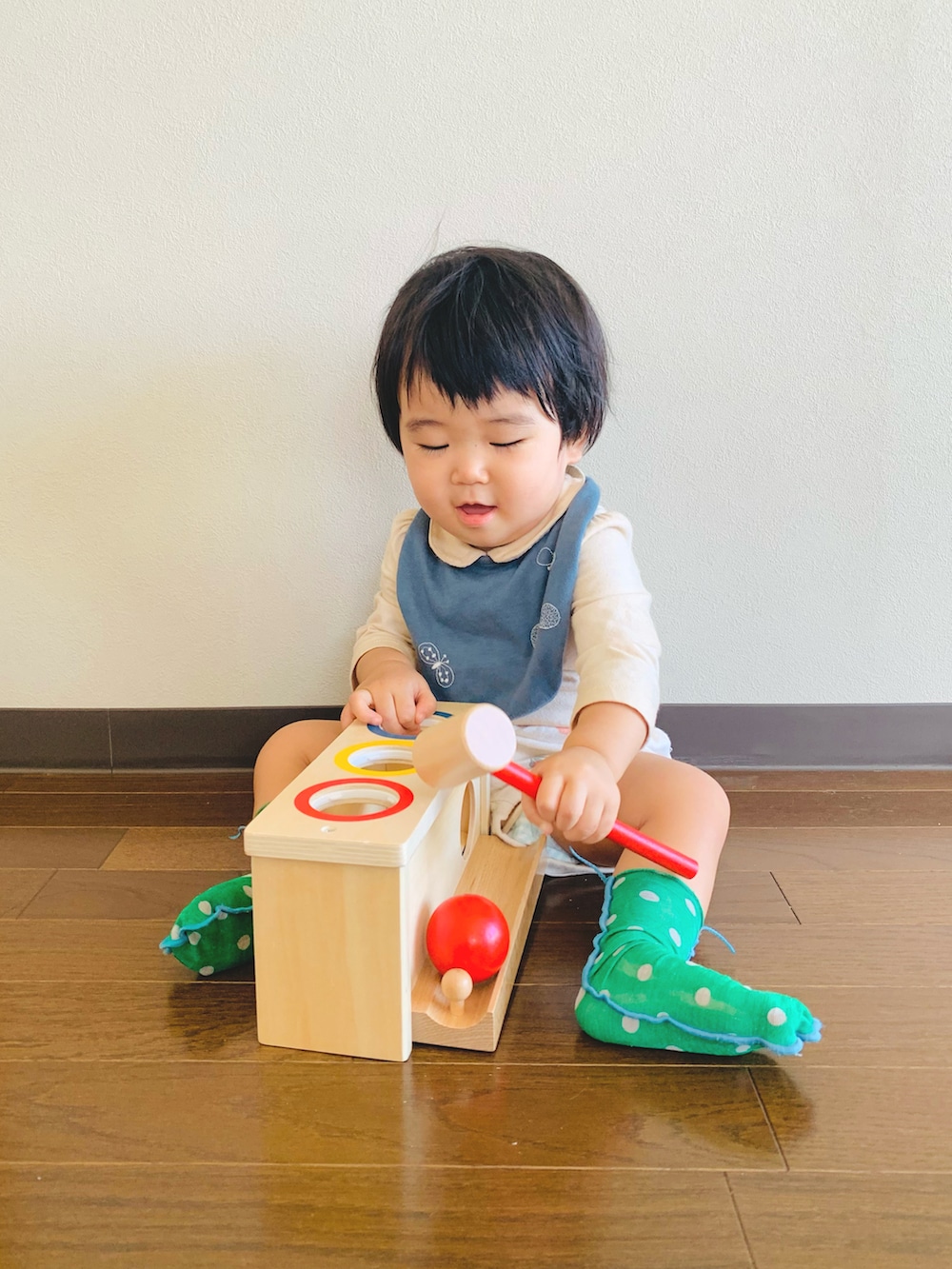 ベージュ系のセットアップ、ブラック系のスタイ/よだれかけ、ホワイト系のロンパースを着用したキッズの秋コーディネートの2枚目の写真