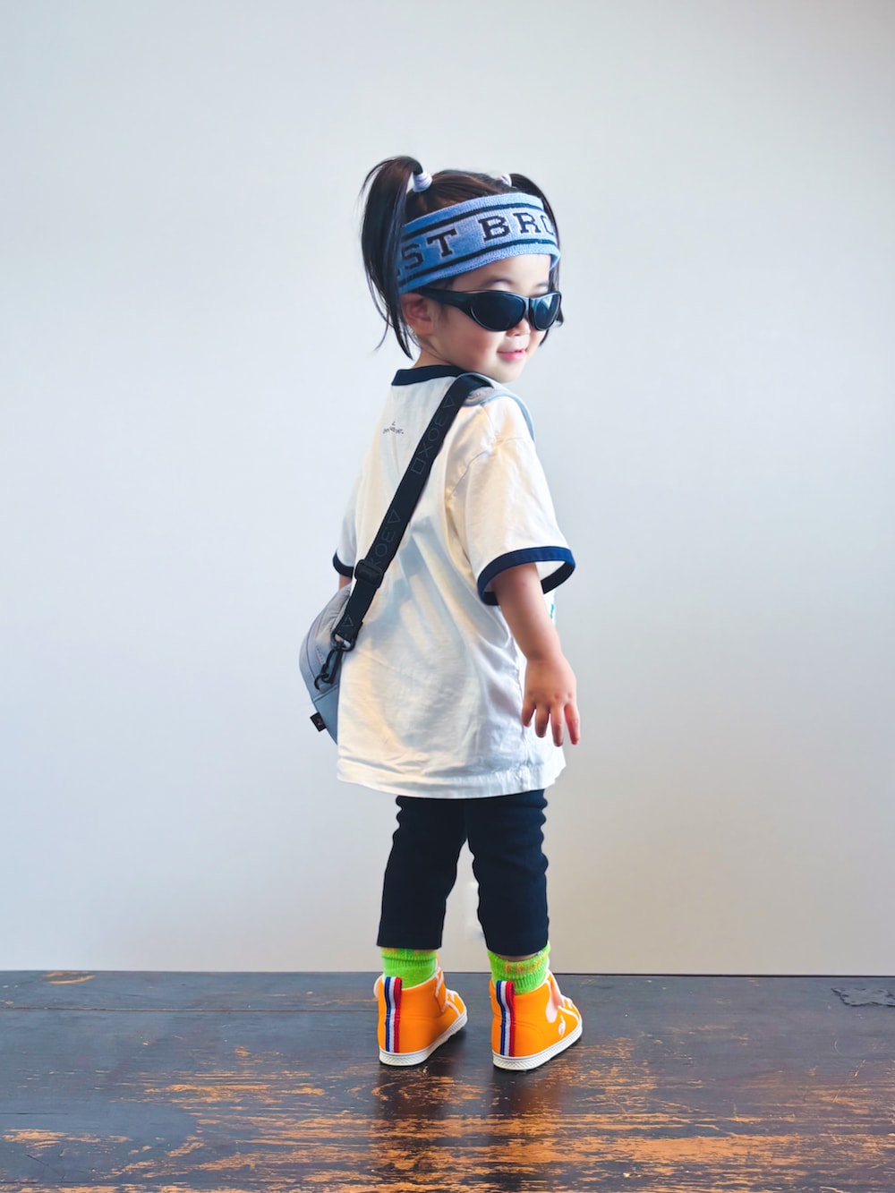 オレンジ系のスニーカー、ホワイト系のTシャツ/カットソー、ブラック系のパンツを着用したキッズの夏コーディネートの4枚目の写真