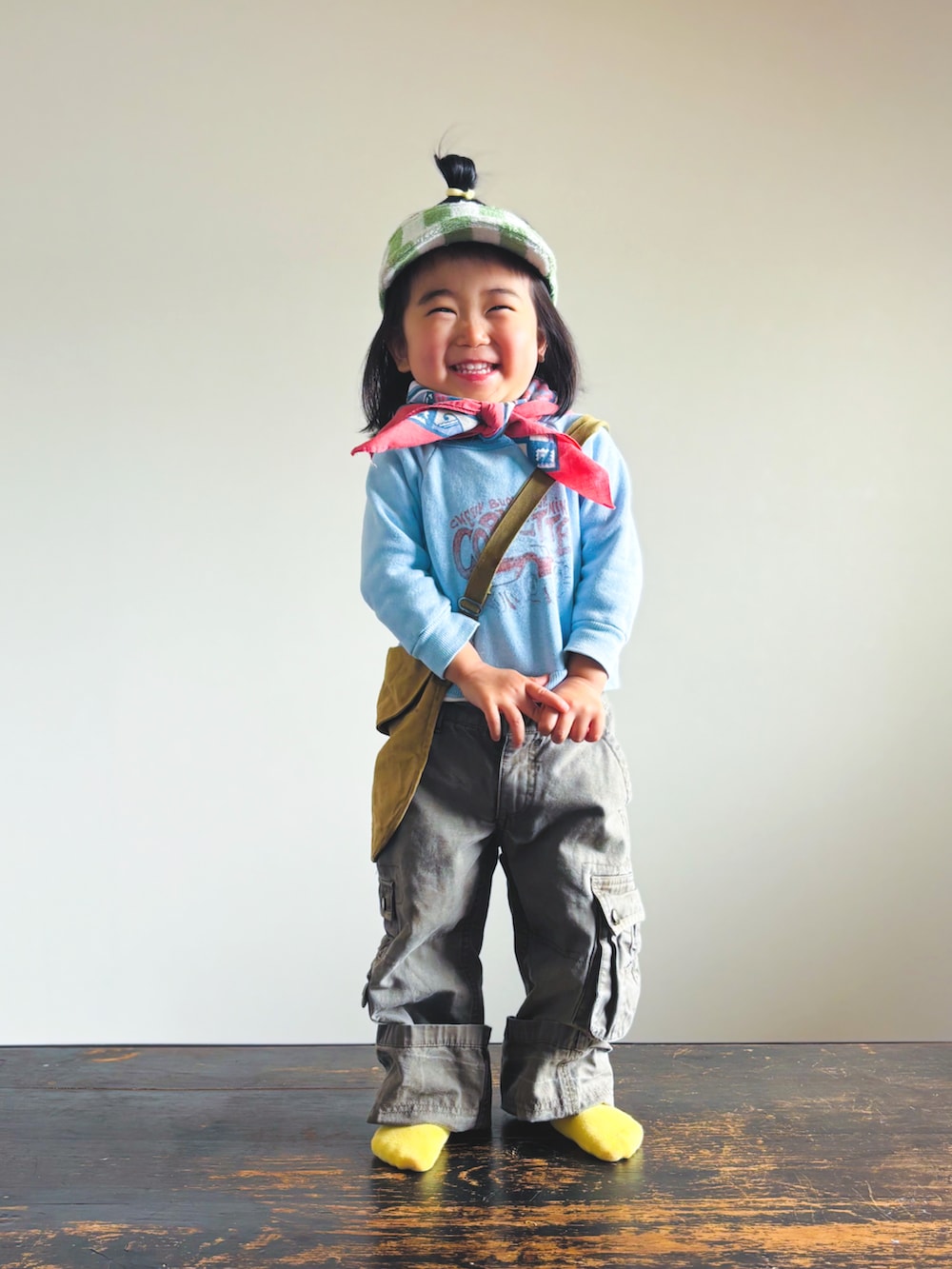 ブルー系のスウェット、グリーン系のショルダーバッグ、グレー系のカーゴパンツを着用したキッズの春コーディネートの2枚目の写真