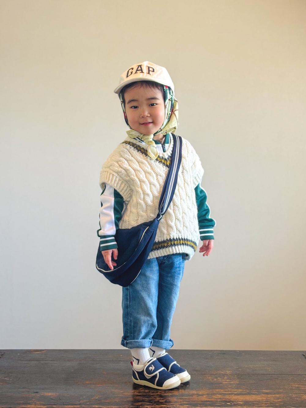 ブルー系のスニーカー、ホワイト系のベスト、グリーン系のジャージを着用したキッズの春コーディネートの2枚目の写真